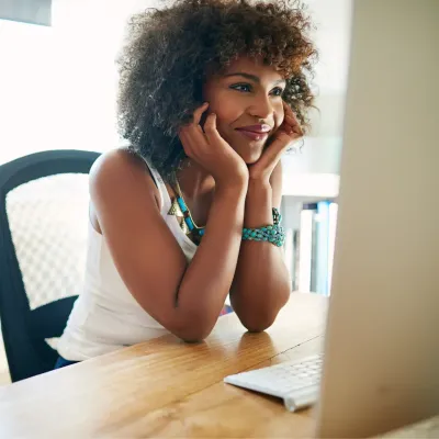 Jonge vrouw die naar computerscherm kijkt Jonge vrouw die naar computerscherm kijkt