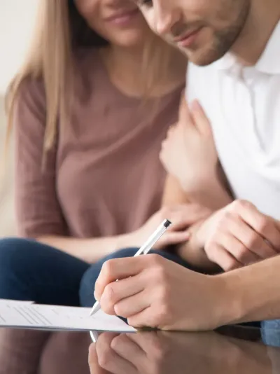 Een jong koppel dat een document tekent Een jong koppel dat een document tekent