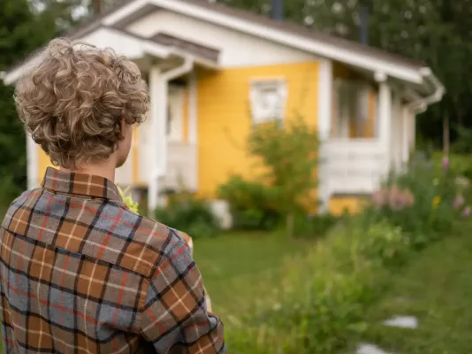 Persoon kijkt naar huisje Persoon kijkt naar huisje
